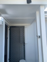 Exterior entry with painted ceiling, posts and security door