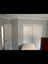 Bedroom painted in grey with white built-in wardrobe doors and trims